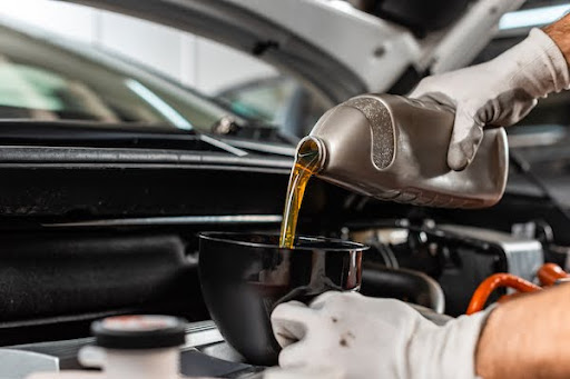 El Paso mechanic pouring motor oil during an oil change service