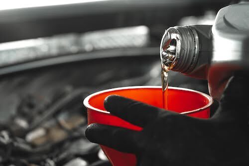 motor oil being poured into a funnel during service